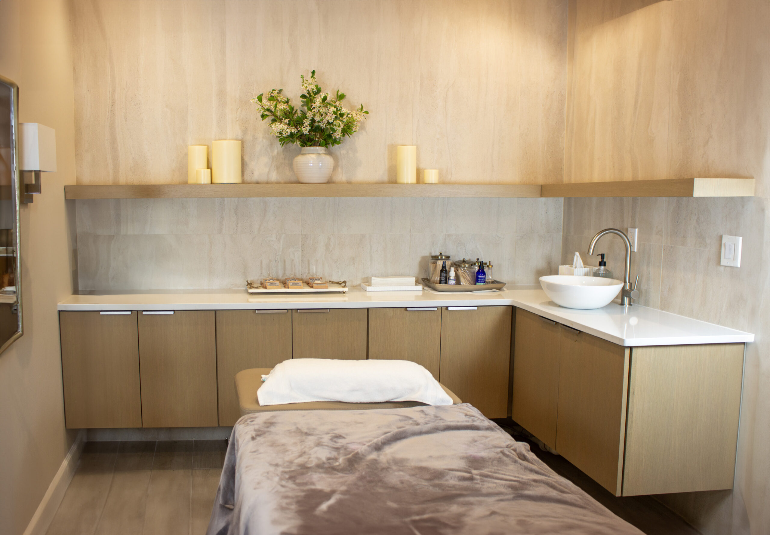 A spa treatment room with wood veneer custom cabinets